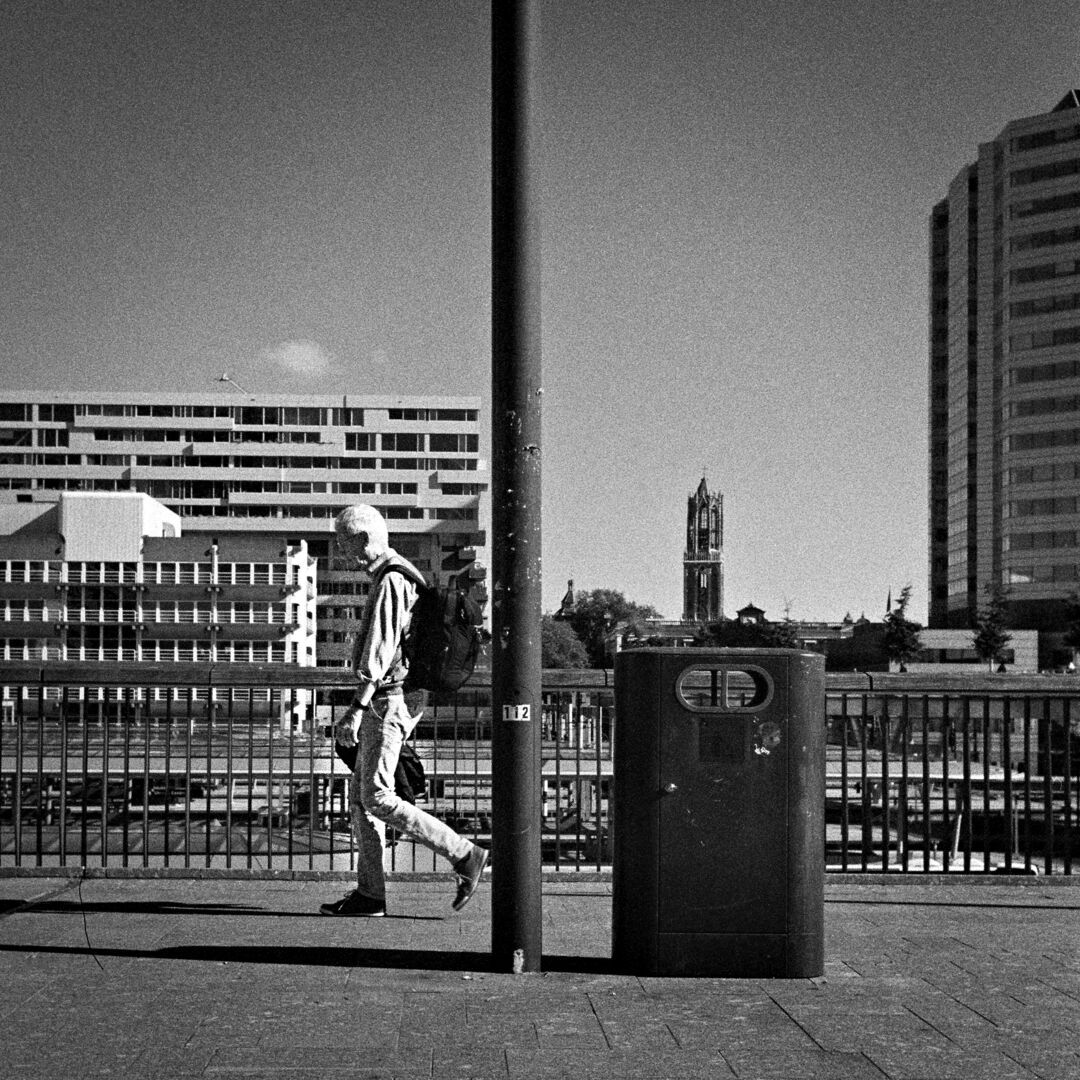 2024-10-09 street photography Utrecht A man a lamp post and a bin