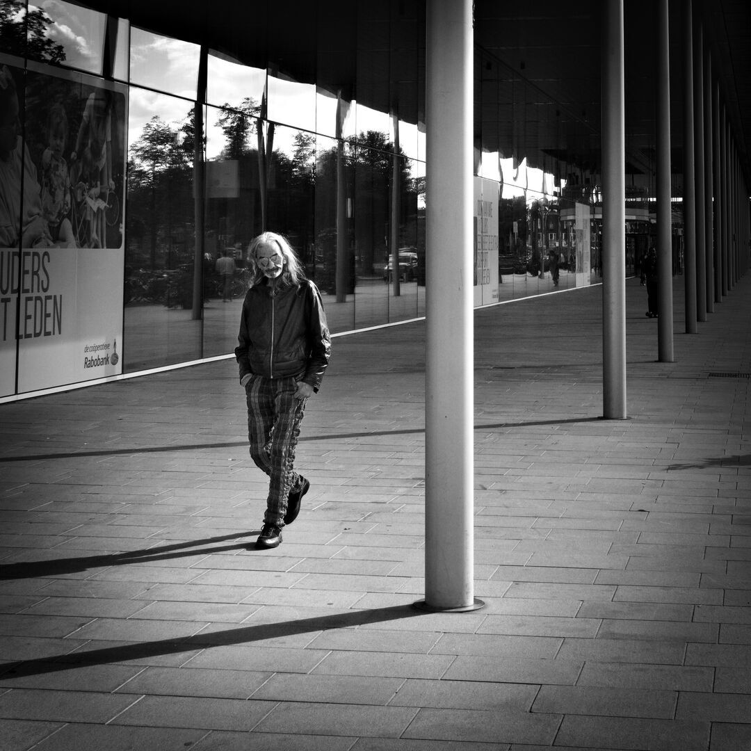 Man walking next to pillars